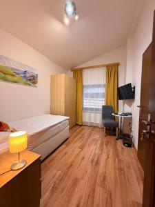a bedroom with a bed and a desk and a tv at Hotel HAAS in Bad Gastein