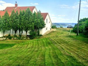 a house on a hill with a green field at Royal Panoráma Vendégház in Pécsely