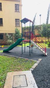a playground with a slide and a slideintend at Cozy Retreat Near Nairobi National Park, Giraffe Centre & Wilson Airport in Nairobi