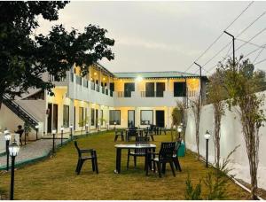 a building with a table and chairs in a yard at The Jungle Castle Resort in Rāmnagar