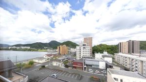 a view of a city with a river and buildings at Hotel BELLMARE in Maizuru