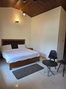 a bedroom with a large bed and two chairs at The Jungle Castle Resort in Rāmnagar +24 photos