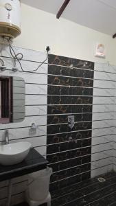 a bathroom with a black and white brick wall at The Jungle Castle Resort in Rāmnagar