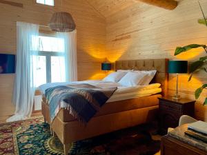 a bedroom with a bed in a wooden room at Torppa, puusauna ja ulkoporeallas in Lahti +46 photos