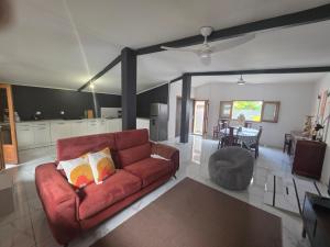 a living room with a red couch and a kitchen at La Petite Case Tomi in Saint-Louis