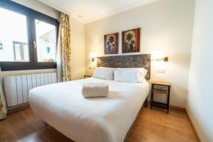 a bedroom with a large white bed and a window at GAV Ciudad in Ronda