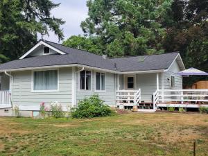 a white house with a black roof at Nice and cozy in Bremerton