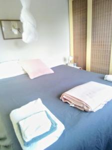 a bedroom with a blue bed with towels on it at Ahu in Piha