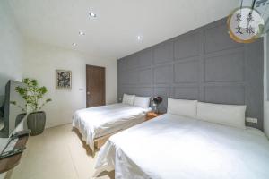 a bedroom with two beds and a large wall at 遇見礁溪-寵物友善-免費停車-無門禁24小時進出-東森文旅-包棟優惠中 in Jiaoxi