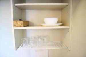 a cupboard with glasses and a bowl on it at Joinus Ise Apartment by Tranova in Ise +4 photos