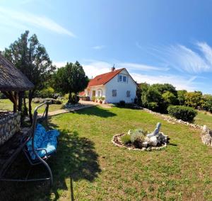 a yard with a house and a statue in the grass at Royal Panoráma Vendégház in Pécsely