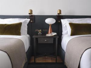 a bedroom with two beds and a table with a lamp at The Bellevue Hotel, in the Unbound Collection by Hyatt in Philadelphia +127 photos