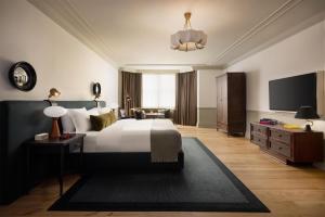 a hotel room with a bed and a tv at The Bellevue Hotel, in the Unbound Collection by Hyatt in Philadelphia