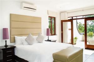 a bedroom with a large white bed and a window at Inn and Out Plus Craighall in Johannesburg +142 photos