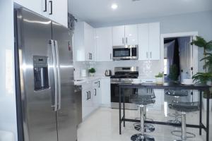 a kitchen with white cabinets and a stainless steel refrigerator at Big apple room 33 in West New York