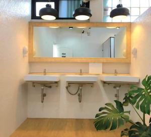 a bathroom with two sinks and a mirror at Bangkok Sleep Nest in Sathani Ban Hua Mak
