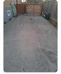 a gravel driveway next to a fence and a building at Bright Room in Walkout Basement in Pickering