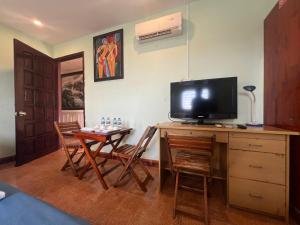a living room with a table and a television on a desk at Kim Long Hotel in Can Tho