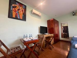 a room with a table and a desk with a television at Kim Long Hotel in Can Tho +30 photos