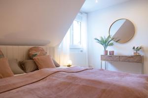 a bedroom with a large bed with a mirror at Heimbi Home No 2 I 4-5 Personen I Familienfreundlich I Balkon I Nähe EuropaPark I Parkplatz I E Ladestation in Schwanau