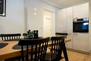 a kitchen with a table with chairs and a microwave at Heimbi Home No 2 I 4-5 Personen I Familienfreundlich I Balkon I Nähe EuropaPark I Parkplatz I E Ladestation in Schwanau
