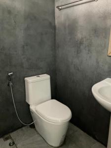 a bathroom with a white toilet and a sink at พี เจ เอ็ม โฮมสเตย์ in Ban Nong Chaeng