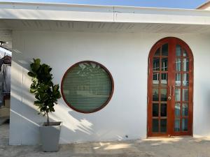 a building with a round window and a potted plant at พี เจ เอ็ม โฮมสเตย์ in Ban Nong Chaeng