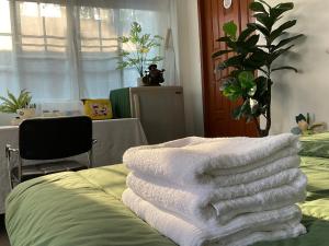 a pile of towels sitting on top of a bed at พี เจ เอ็ม โฮมสเตย์ in Ban Nong Chaeng +3 photos