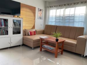 a living room with a couch and a coffee table at พี เจ เอ็ม โฮมสเตย์ in Ban Nong Chaeng