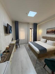 a hotel room with a bed and a desk at The Tower Hotel Tashkent by HotelPro Group in Tashkent