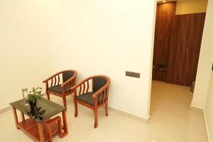two chairs and a table in a room at South Forest Wayanad By Bestinn Leisure in Sultan Bathery