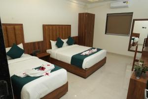 a hotel room with two beds and a mirror at South Forest Wayanad By Bestinn Leisure in Sultan Bathery +25 photos