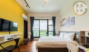 a bedroom with a bed and a desk and a tv at 象日葵民宿-寵物友善-無門禁24小時進出-免費停車-東森文旅-包棟優惠中 in Wujie