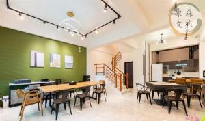a dining room with tables and chairs and a green wall at 象日葵民宿-寵物友善-無門禁24小時進出-免費停車-東森文旅-包棟優惠中 in Wujie