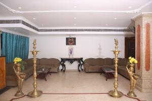 a living room with couches and a table at Sai Kirshanth Residency in Karaikal