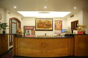 a large wooden bar in a room with paintings on the wall at Sai Kirshanth Residency in Karaikal