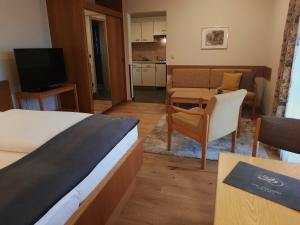 a hotel room with a bed and a living room at Appartementhaus Gaby in Bad Füssing