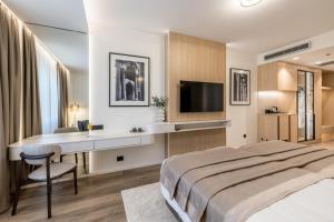 a hotel room with a bed and a desk and a television at Hotel Atrium in Split