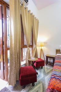 a room with two beds and a window with curtains at Matrika Stays in Lucknow