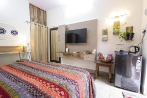 a bedroom with a bed and a flat screen tv at Matrika Stays in Lucknow