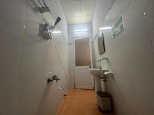 a small bathroom with a sink and a shower at Kim Long Hotel in Can Tho