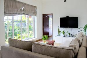 a living room with a couch and a flat screen tv at Tailors Cottage in Hatton