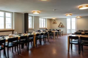 a dining room with tables and chairs and windows at Zermatt Youth Hostel in Zermatt