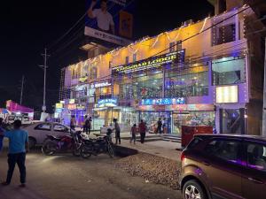 a busy city street at night with cars and people at Ashirbad Lodge in Guwahati