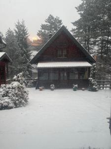 a house with a snow covered yard in front of it at Brvnara M&M Kaludjerske bare in Kaludjerske Bare +9 photos