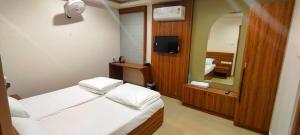 a hotel room with two beds and a mirror at MALAPPURAM RESIDENCY in Malappuram
