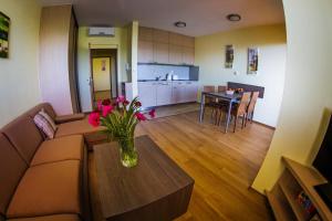 a living room with a couch and a table with flowers at Vendelin Apartmany in Bojnice