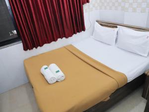 a hotel room with a bed with two pillows at Shree Residency in Airoli +7 photos