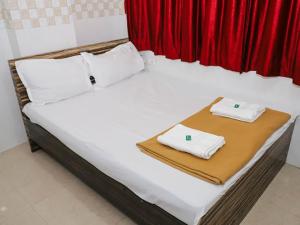 a white bed with two towels on top of it at Shree Residency in Airoli