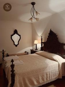 a bedroom with a bed and a mirror on the wall at Refúgio da Geira in Campo do Gerês